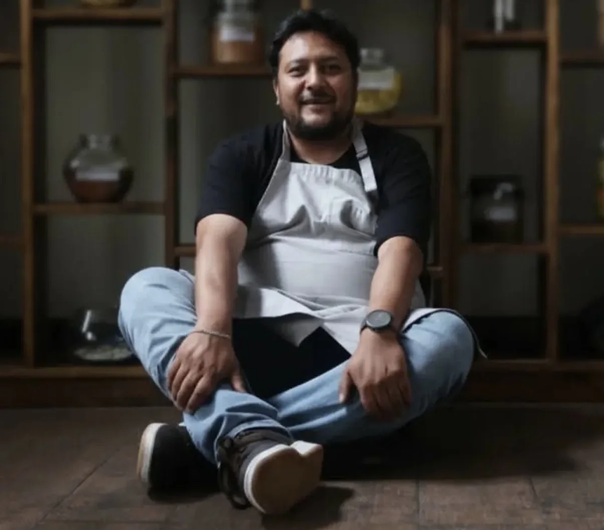 El chef Pablo Gumiel sentado frente a la despensa de Nativa