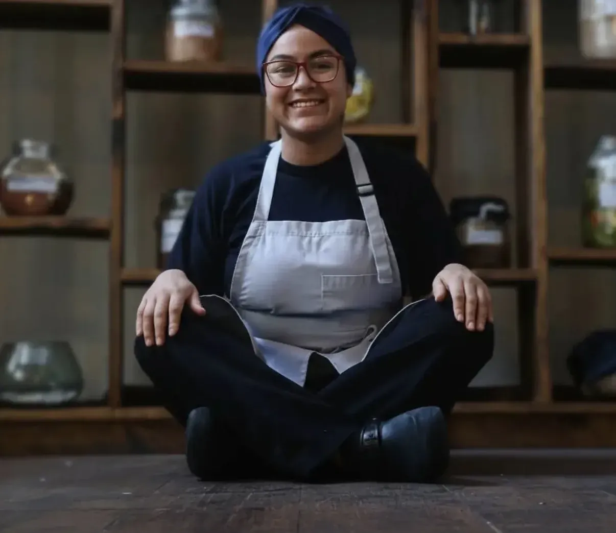 Integrante del equipo de Nativa sonriendo, sentada frente a la despensa